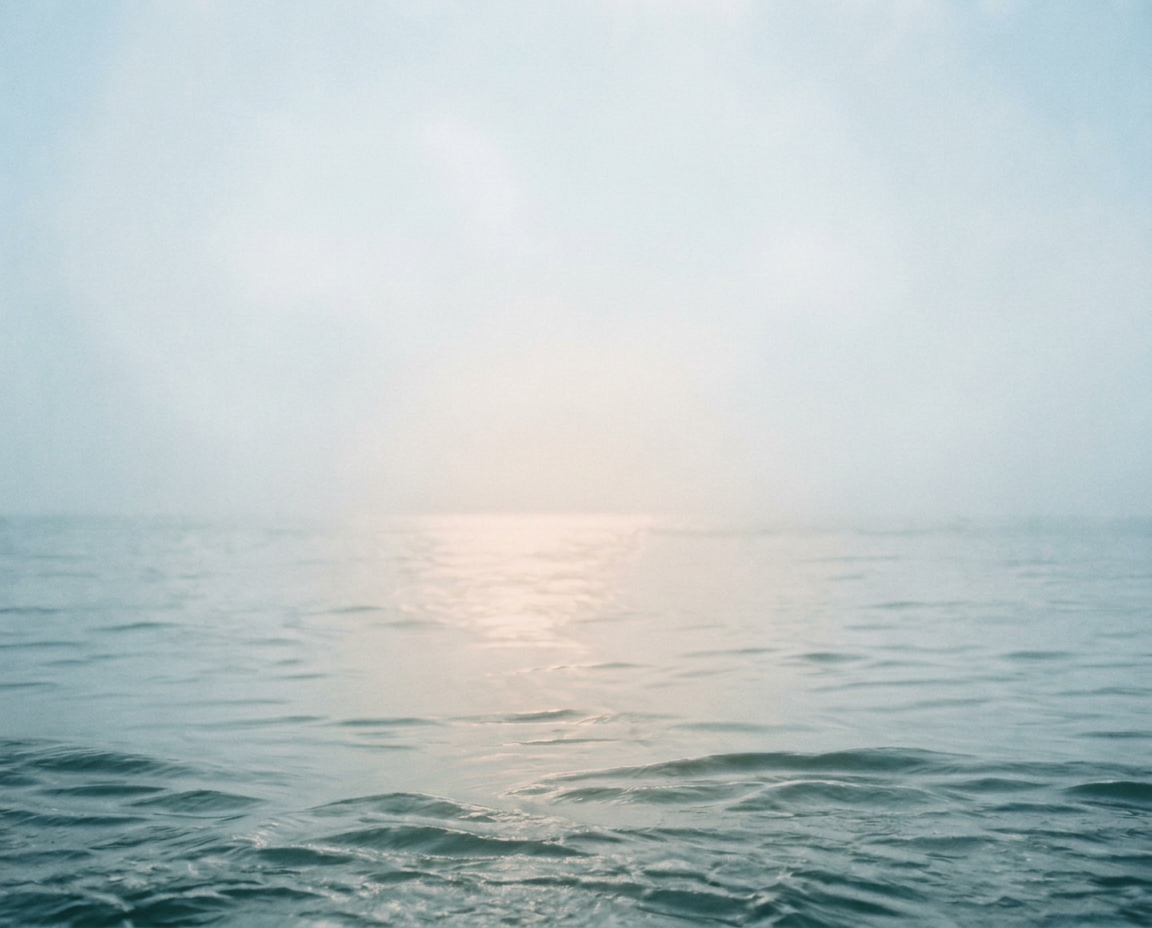 Stilles Wasser in gedämpftem, körnigem Morgenlicht